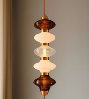 Decorative pendant light with tiered glass shades on a neutral background