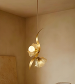 Gold pendant light fixture against a beige wall