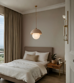 Modern bedroom with a bed, pendant light, and side table.