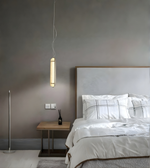 Modern bedroom with a bed, nightstand, and pendant light.
