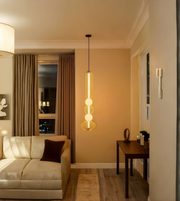 Modern living room with beige sofa, pendant light, and wooden table.