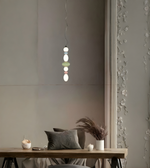 Modern pendant light hanging above a wooden table with decorative elements.