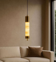 Pendant light fixture hanging above a beige sofa with a neutral wall background
