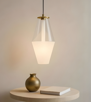 Modern pendant light with clear glass shade and gold fixture on a neutral background