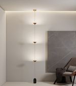 Modern pendant light fixture in a minimalistic room with a gray wall and chair.