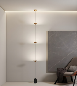 Modern pendant light fixture in a minimalistic room with a gray wall and chair.