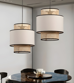 Modern pendant lights hanging above a dining table with a neutral background