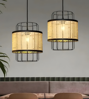 Two pendant lights with woven design and black metal frames hanging above a dining table.