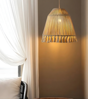 Woven pendant light hanging in a room with white curtains and a neutral wall.