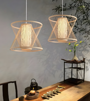 Two woven pendant lights hanging above a wooden table with tea set and decorative items.