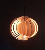 Wooden pendant light with a warm glow against a dark background