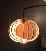 Wooden pendant light with a warm glow against a dark background