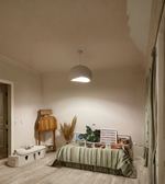 Bedroom with a bed, desk, and decorative items on a neutral background
