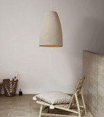 Beige pendant lamp hanging above a wooden chair with a cushion in a minimalistic room.