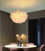 Modern pendant light hanging above a dining table with decorative plants in a room.