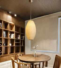 Dining room with wooden table, chairs, and a bookshelf.