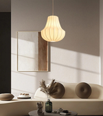 Modern pendant light hanging above a minimalistic living room setup with a mirror and decorative items.
