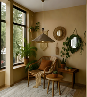 Cozy living room with a wicker chair, round mirror, and potted plants.