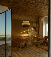 Dining area with wooden tables and chairs in a modern interior setting.