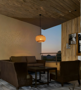 Modern living room with wooden ceiling, brown sofa, and wall art.