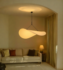 Modern pendant light in a living room setting with a beige sofa and lamp.