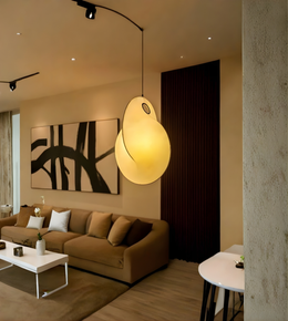 Modern living room with a brown sofa, abstract painting, and pendant light.