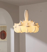 Modern pendant light hanging in a room with neutral walls and a piece of abstract art.