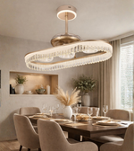Luxury wave crystal fan chandelier with gold finish installed above a modern dining table