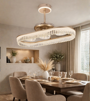Luxury wave crystal fan chandelier with gold finish installed above a modern dining table