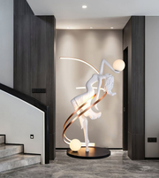 Illuminated dancer sculpture floor lamp with glowing spheres in a luxury modern interior
