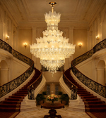 Luxury multi tier crystal chandelier installed in a grand double height staircase and royal living room
