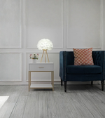 Modern feather table lamp glowing softly in a living room setting