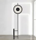 Modern circular LED floor lamp with black metal frame in minimalist interior