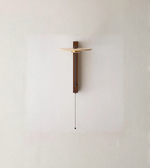 Minimal modern wall sconce with pull chain mounted on a neutral wall