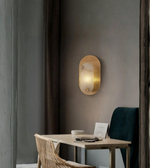 Luxury oval wall sconce mounted beside a desk in a contemporary interior