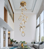 Modern gold cascading ring chandelier installed in double height luxury living room