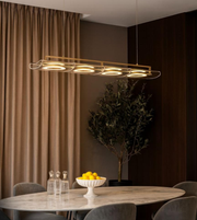 Modern linear LED ring pendant light hanging above dining table in contemporary dining room