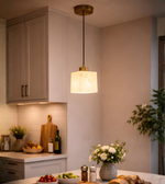 Modern marble effect cube pendant light with brass finish hanging above kitchen island with warm ambient lighting