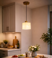 Modern marble effect cube pendant light with brass finish hanging above kitchen island with warm ambient lighting