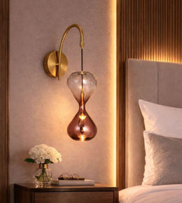 Modern hourglass glass wall light beside luxury bed