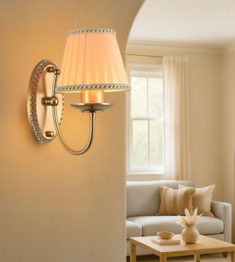 Classic gold wall sconce with fabric lampshade giving warm light in living room