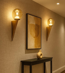 Modern gold wall sconce with glass globe light mounted on hallway wall