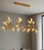 Gold leaf chandelier hanging in a room with a neutral color scheme.