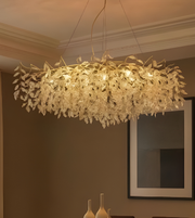 Decorative chandelier hanging in a room with a mirror and vases on a table.