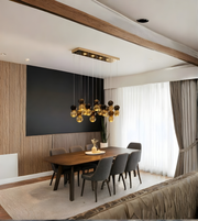 Modern dining room with a chandelier, wooden table, and gray chairs.