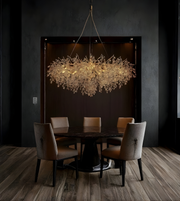 Dining room with a modern chandelier hanging above a round table and chairs.