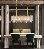 Modern dining room with a chandelier, table, and chairs.