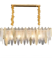 Chandelier with gold frame and feather-like glass elements on a white background