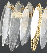 Decorative wall sconces with gold and clear glass design on a dark background