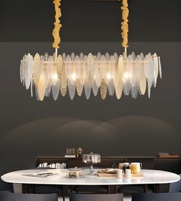 Modern chandelier hanging above a dining table with a dark wall background